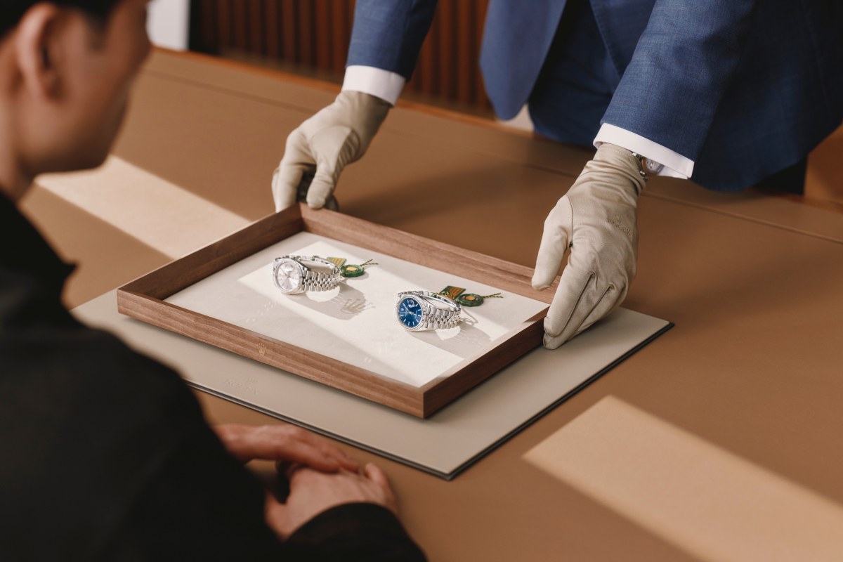 Persönliche Kundenberatung — Rolex Modelle auf Präsentationstablett