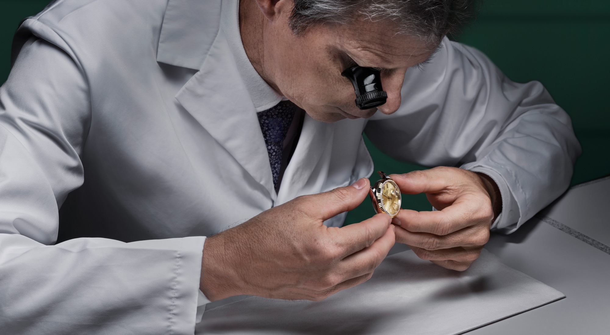 Rolex Uhrmacher untersucht eine Armbanduhr mit der Lupe — Diagnose